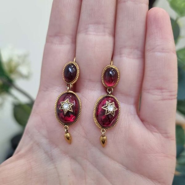 Victorian Antique Garnet and Diamond Drop Earrings, oval cabochon garnets suspend larger oval garnets with rose cut diamonds set to central stars in 18ct yellow gold with twisted gold wire surrounds and gold conical tear drops. Late 19th century Circa 1870