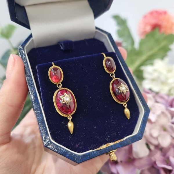 Victorian Antique Garnet and Diamond Drop Earrings, oval cabochon garnets suspend larger oval garnets with rose cut diamonds set to central stars in 18ct yellow gold with twisted gold wire surrounds and gold conical tear drops. Late 19th century Circa 1870