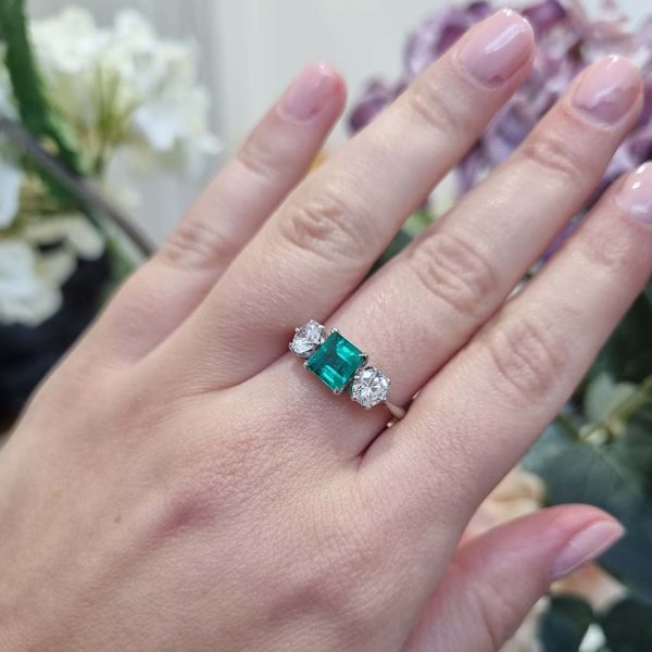 Art Deco Colombian Emerald and Diamond Trilogy Three Stone Engagement Ring, 1.25ct octagonal step-cut Colombian emerald flanked by 1ct old European transition cut diamonds in platinum