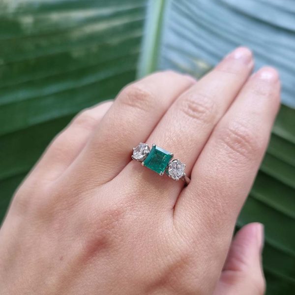 Art Deco Colombian Emerald and Diamond Trilogy Three Stone Engagement Ring, 1.25ct octagonal step-cut Colombian emerald flanked by 1ct old European transition cut diamonds in platinum