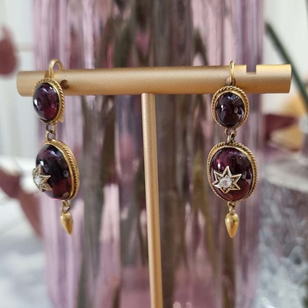 Victorian Antique Garnet and Diamond Drop Earrings, oval cabochon garnets suspend larger oval garnets with rose cut diamonds set to central stars in 18ct yellow gold with twisted gold wire surrounds and gold conical tear drops. Late 19th century Circa 1870