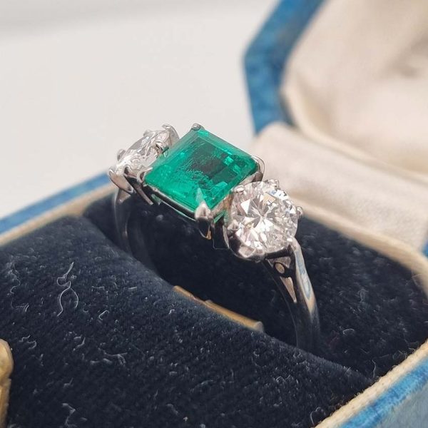 Art Deco Colombian Emerald and Diamond Trilogy Three Stone Engagement Ring, 1.25ct octagonal step-cut Colombian emerald flanked by 1ct old European transition cut diamonds in platinum