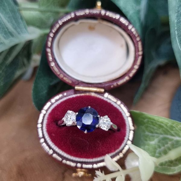 Art Deco 1.69ct Sapphire and Diamond Trilogy Three Stone Engagement Ring in Platinum, 1.69ct oval cushion-shaped Royal blue sapphire flanked by 0.60cts old mine-cut diamonds