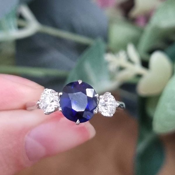 Art Deco 1.69ct Sapphire and Diamond Trilogy Three Stone Engagement Ring in Platinum, 1.69ct oval cushion-shaped Royal blue sapphire flanked by 0.60cts old mine-cut diamonds