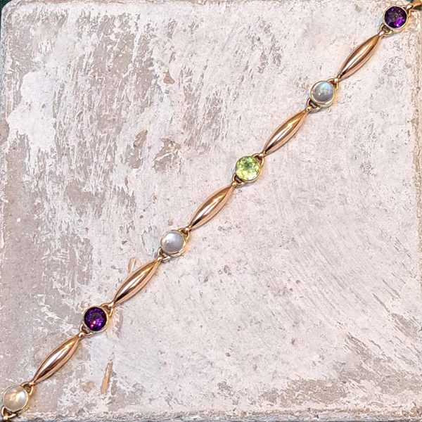 Edwardian Antique Suffragette Peridot and Amethyst Bracelet, 15ct yellow gold bracelet set with gemstones symbolic of the suffragette movement; moonstone, peridot and amethyst