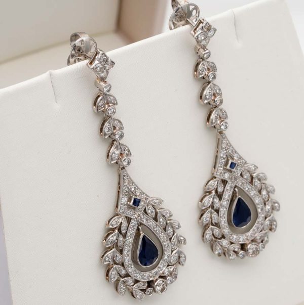 Antique Belle Epoque Edwardian Sapphire and Diamond Cluster Drop Earrings in Platinum, pear-shaped blue sapphires suspended within diamond wreath clusters from diamond leaf work drops, Circa 1905