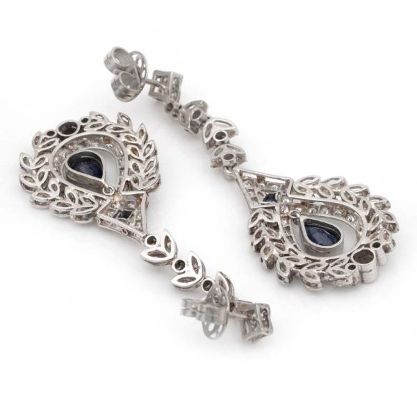 Edwardian Belle Epoque Antique Sapphire and Diamond Cluster Drop Earrings in Platinum, pear-shaped blue sapphires suspended within diamond wreath clusters from diamond leaf work drops, Circa 1905