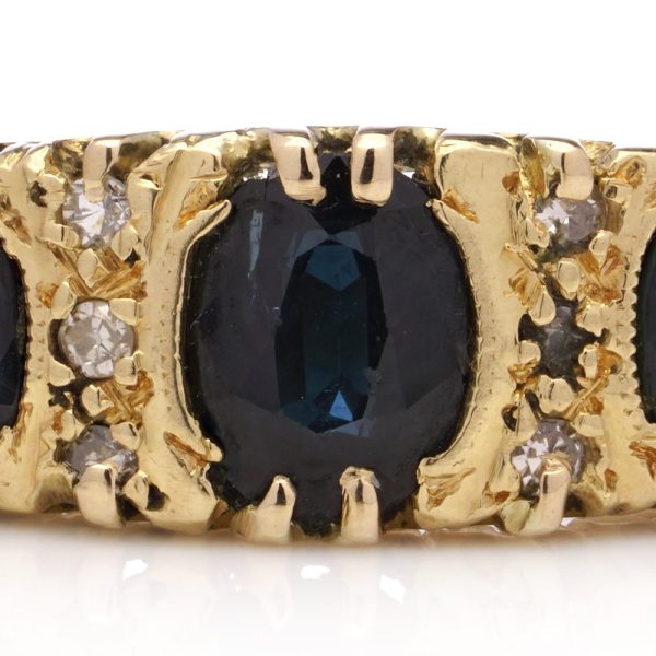 Vintage three stone sapphire ring with diamonds in gold.