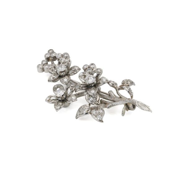Platinum and diamond flower branch brooch.