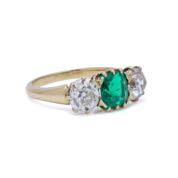 Antique emerald and diamond three-stone ring in gold.