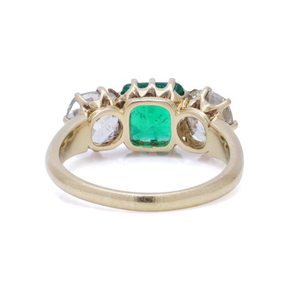Antique emerald and diamond three-stone ring in gold.