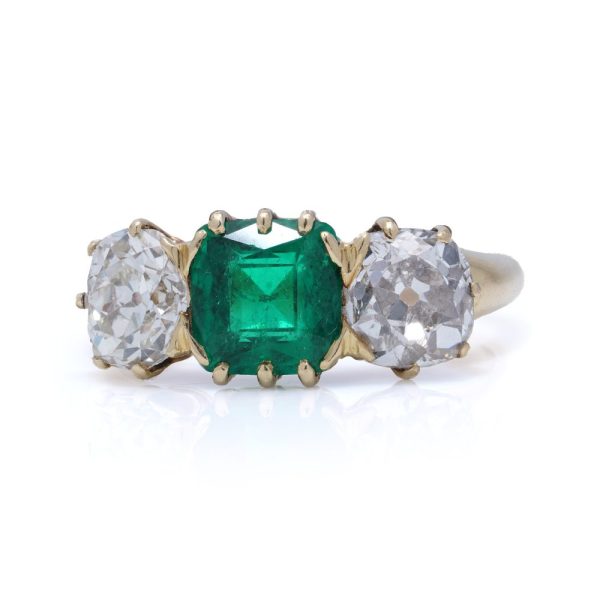 Antique emerald and diamond three-stone ring in gold.
