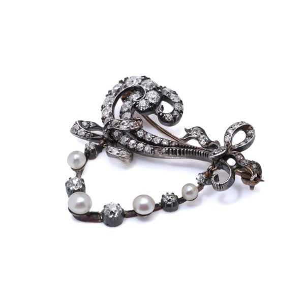 Edwardian diamond and pearl brooch in gold and silver.