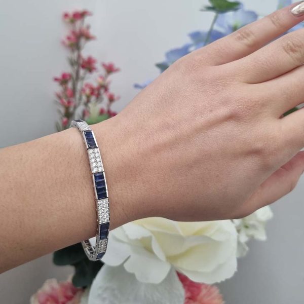 5ct Baguette Cut Sapphire and Diamond Line Bracelet, 5cts baguette blue sapphires and 0.50cts brilliant-cut diamonds in alternating sections in elegant graduating design in 18ct white gold