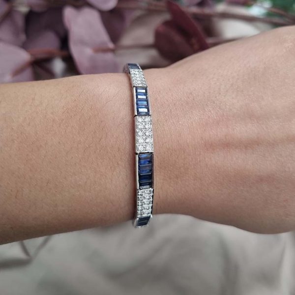 5ct Baguette Cut Sapphire and Diamond Line Bracelet, 5cts baguette blue sapphires and 0.50cts brilliant-cut diamonds in alternating sections in elegant graduating design in 18ct white gold