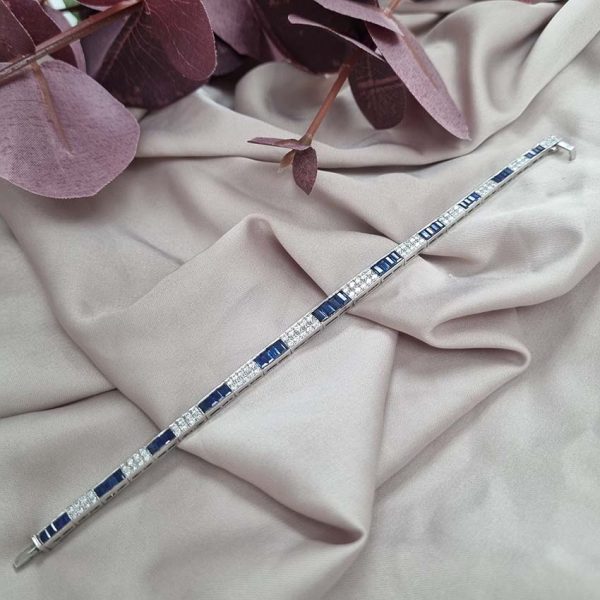5ct Baguette Cut Sapphire and Diamond Line Bracelet, 5cts baguette blue sapphires and 0.50cts brilliant-cut diamonds in alternating sections in elegant graduating design in 18ct white gold