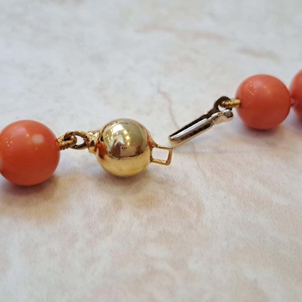 Antique Japanese Momo Coral and Gold Graduated Bead Necklace, single strand graduating orange-pink Momo coral and 18ct yellow gold disc beads with 14ct yellow gold bead clasp