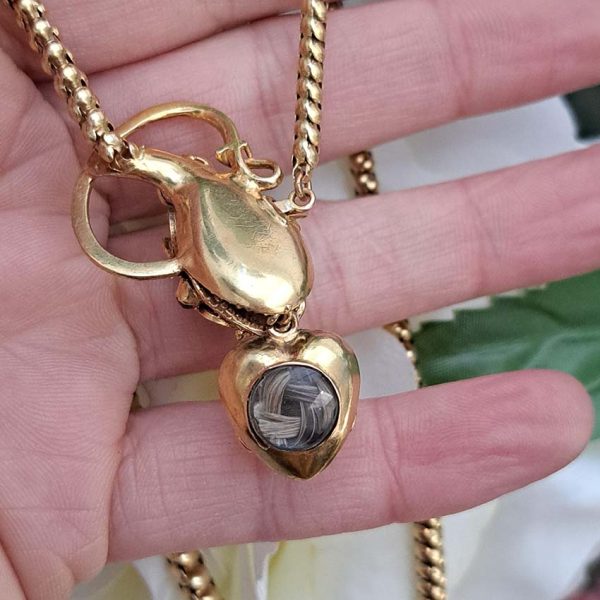 Victorian Antique Garnet and Gold Snake Necklace, intricate articulated 18ct yellow gold scales to snake's head with oval cabochon garnet suspending heart shaped locket pendant with lock of hair to the reverse. Circa 1850