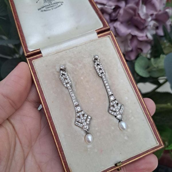 Antique Art Deco Natural Pearl and Diamond Drop Earrings, graduated geometric designs studded with 2 carats of sparkling diamonds leading to natural pearl pendant drops in platinum