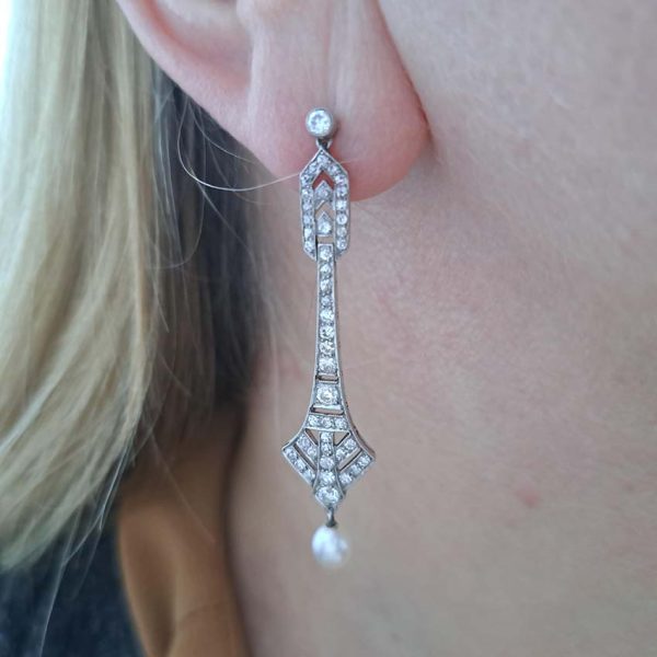 Antique Art Deco Natural Pearl and Diamond Drop Earrings, graduated geometric designs studded with 2 carats of sparkling diamonds leading to natural pearl pendant drops in platinum