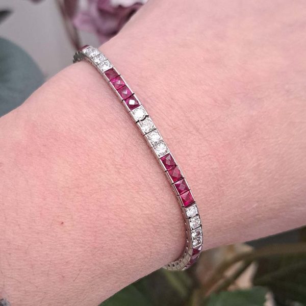 Art Deco Charles Holl 5ct Ruby and Diamond Line Bracelet, set with alternating sections of square French cut rubies and sparkling transitional cut diamonds in platinum and 18ct white gold