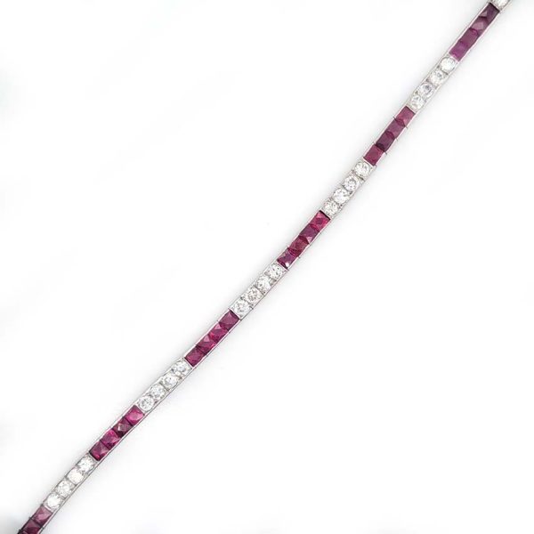 Art Deco Charles Holl 5ct Ruby and Diamond Line Bracelet, set with alternating sections of square French cut rubies and sparkling transitional cut diamonds in platinum and 18ct white gold