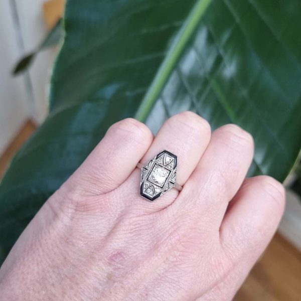 Art Deco Old Cut Diamond and Onyx Cluster Plaque Ring, 0.70ct old mine-cut diamond within tapered geometric surround of sparkling diamonds accented with rich black onyx in platinum. Circa 1920s
