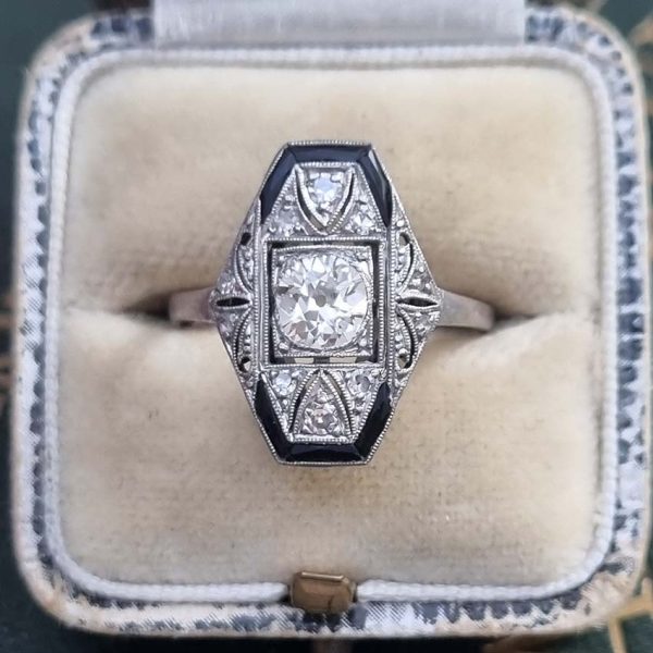 Art Deco Old Cut Diamond and Onyx Cluster Plaque Ring, 0.70ct old mine-cut diamond within tapered geometric surround of sparkling diamonds accented with rich black onyx in platinum. Circa 1920s