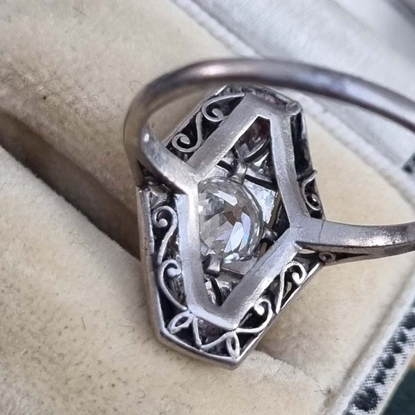 Art Deco Old Cut Diamond and Onyx Cluster Plaque Ring, 0.70ct old mine-cut diamond within tapered geometric surround of sparkling diamonds accented with rich black onyx in platinum. Circa 1920s