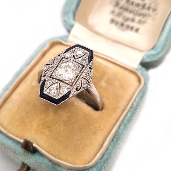 Art Deco Old Cut Diamond and Onyx Cluster Plaque Ring, 0.70ct old mine-cut diamond within tapered geometric surround of sparkling diamonds accented with rich black onyx in platinum. Circa 1920s