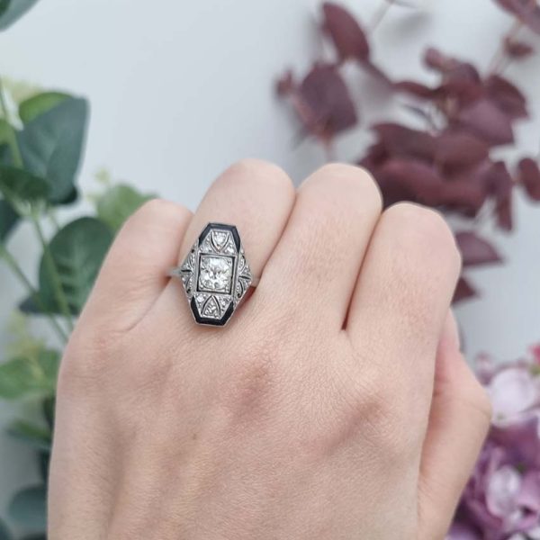 Art Deco Old Cut Diamond and Onyx Cluster Plaque Ring, 0.70ct old mine-cut diamond within tapered geometric surround of sparkling diamonds accented with rich black onyx in platinum. Circa 1920s
