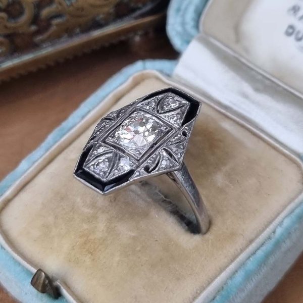 Art Deco Old Cut Diamond and Onyx Cluster Plaque Ring, 0.70ct old mine-cut diamond within tapered geometric surround of sparkling diamonds accented with rich black onyx in platinum. Circa 1920s