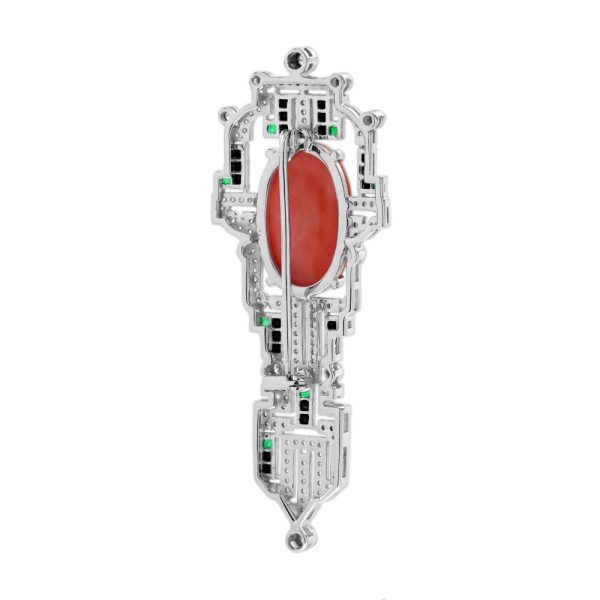 Art Deco Inspired Coral Onyx and Diamond Brooch, vivid orange 6.32ct oval coral within diamond geometric frame with contrasting black onyx and green emerald accents in 14ct white gold