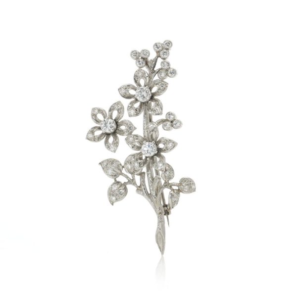 Platinum and diamond flower branch brooch.