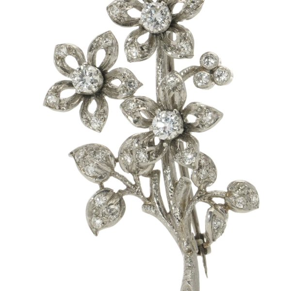Platinum and diamond flower branch brooch.