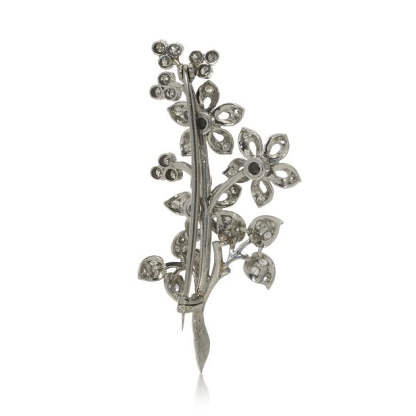 Platinum and diamond flower branch brooch.