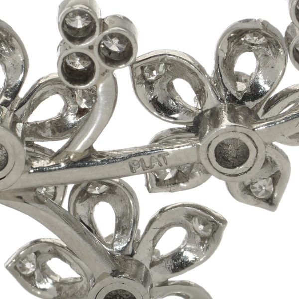 Platinum and diamond flower branch brooch.