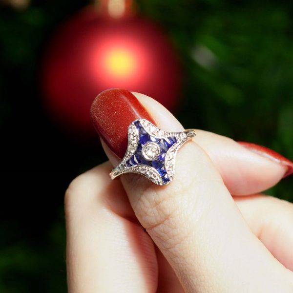 Diamond and Sapphire Navette Cluster Plaque Ring, central sparkling diamond surrounded by calibre French-cut blue sapphires within outer diamond border in 14ct white gold