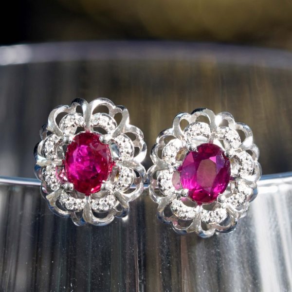 2ct Ruby and Diamond Flower Cluster Stud Earrings, oval red rubies within diamond halo surround and outer gold floral design border in 14ct white gold