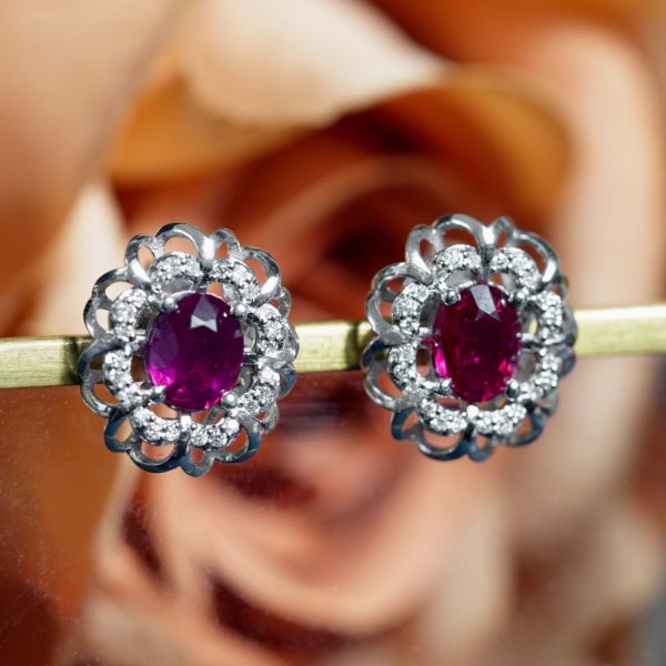 2ct Ruby and Diamond Flower Cluster Stud Earrings, oval red rubies within diamond halo surround and outer gold floral design border in 14ct white gold