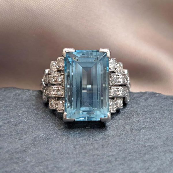 Art Deco 5.5ct Aquamarine and Diamond Dress Ring, rectangular step-cut aquamarine flanked by stepped geometric diamond shoulders in platinum. Circa 1920s