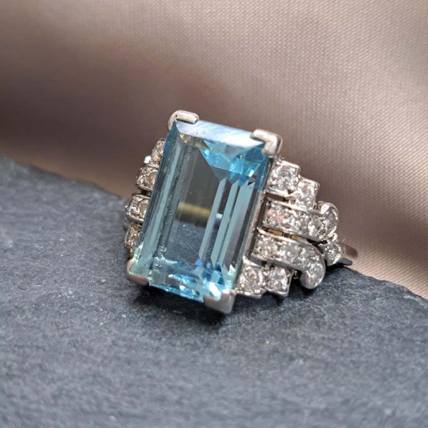 Art Deco 5.5ct Aquamarine and Diamond Dress Ring, rectangular step-cut aquamarine flanked by stepped geometric diamond shoulders in platinum. Circa 1920s