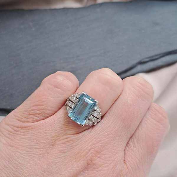 Art Deco 5.5ct Aquamarine and Diamond Dress Ring, rectangular step-cut aquamarine flanked by stepped geometric diamond shoulders in platinum. Circa 1920s