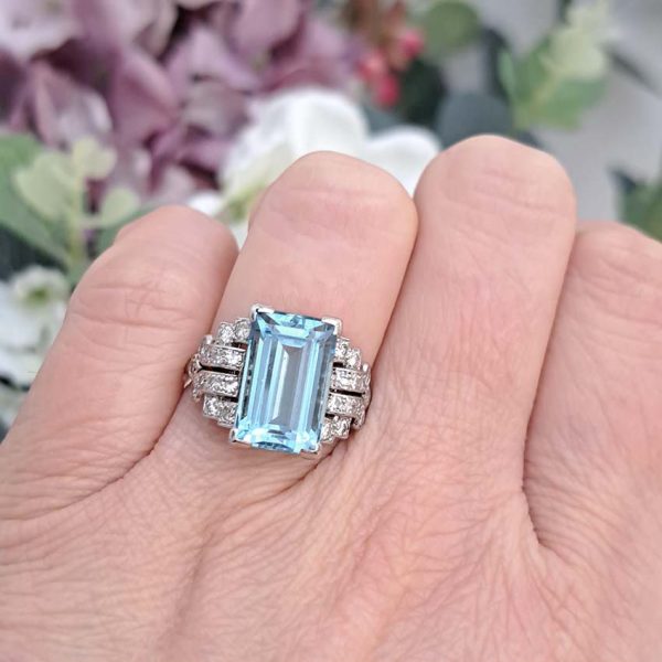 Art Deco 5.5ct Aquamarine and Diamond Dress Ring, rectangular step-cut aquamarine flanked by stepped geometric diamond shoulders in platinum. Circa 1920s