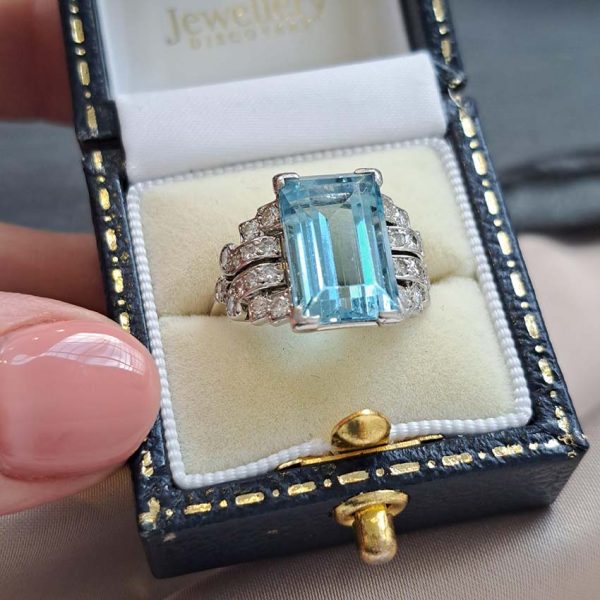Art Deco 5.5ct Aquamarine and Diamond Dress Ring, rectangular step-cut aquamarine flanked by stepped geometric diamond shoulders in platinum. Circa 1920s