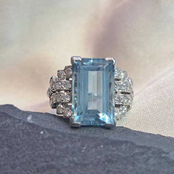 Art Deco 5.5ct Aquamarine and Diamond Dress Ring, rectangular step-cut aquamarine flanked by stepped geometric diamond shoulders in platinum. Circa 1920s