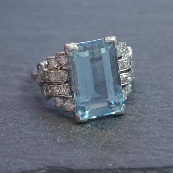Art Deco 5.5ct Aquamarine and Diamond Dress Ring, rectangular step-cut aquamarine flanked by stepped geometric diamond shoulders in platinum. Circa 1920s