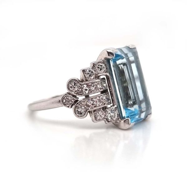Art Deco 5.5ct Aquamarine and Diamond Dress Ring, rectangular step-cut aquamarine flanked by stepped geometric diamond shoulders in platinum. Circa 1920s