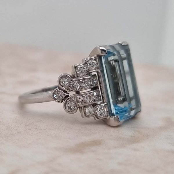 Art Deco 5.5ct Aquamarine and Diamond Dress Ring, rectangular step-cut aquamarine flanked by stepped geometric diamond shoulders in platinum. Circa 1920s