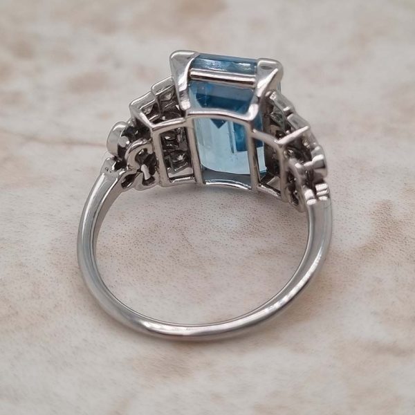 Art Deco 5.5ct Aquamarine and Diamond Dress Ring, rectangular step-cut aquamarine flanked by stepped geometric diamond shoulders in platinum. Circa 1920s